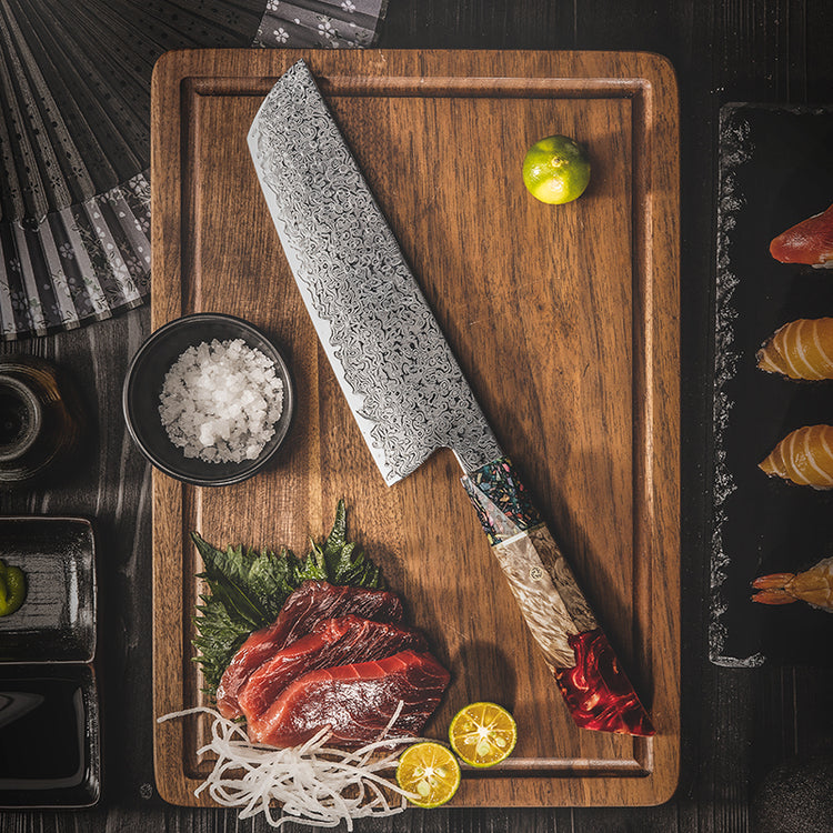 Top-down view of the Damara Ryujin Kiritsuke knife on a board with sliced raw beef, sea salt, and lime.