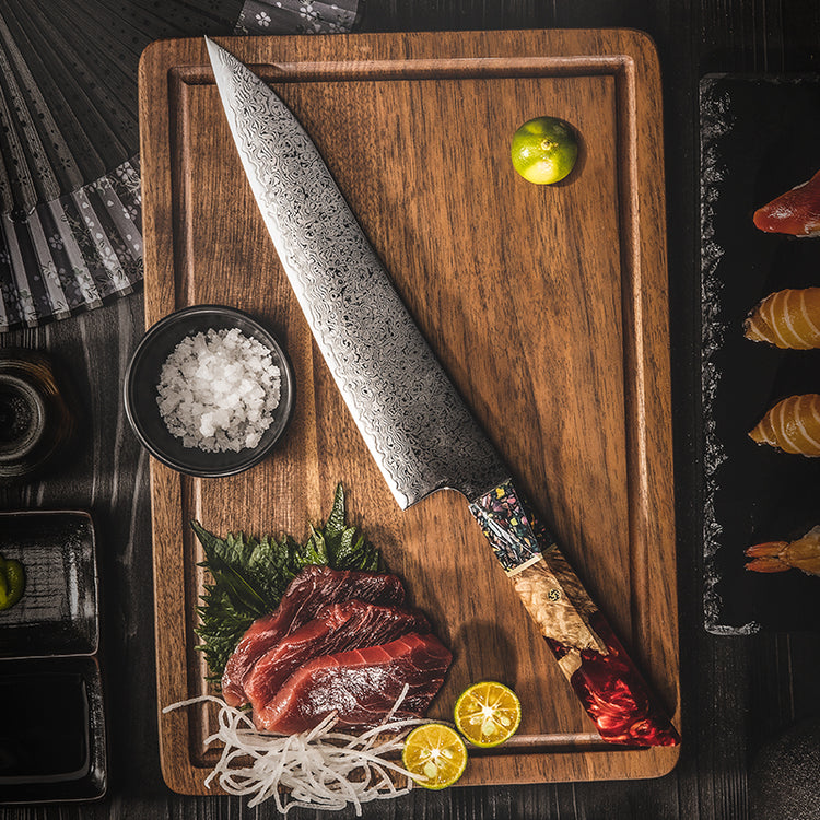 Overhead shot of the Damara Kensei knife next to freshly sliced tuna, sea salt, and other gourmet ingredients